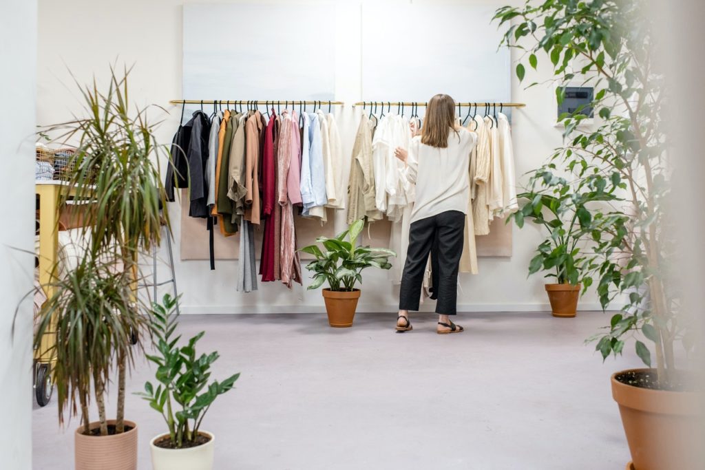 woman choosing clothes - rack of shirt
