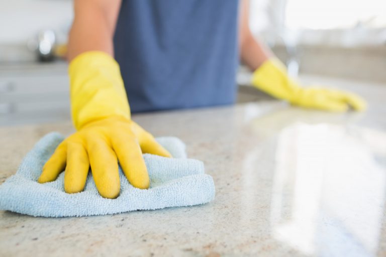 woman sanitizing a countertop