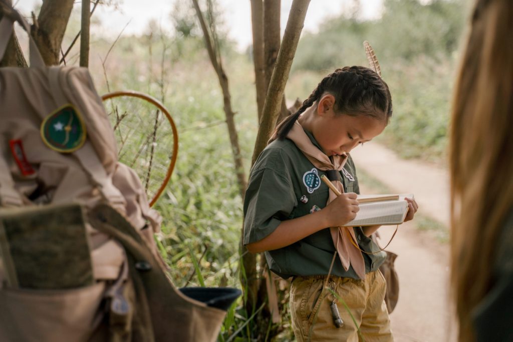 child taking notes in wilderness