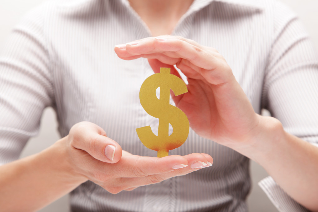 a woman holding a paper dollar sign to represent funding