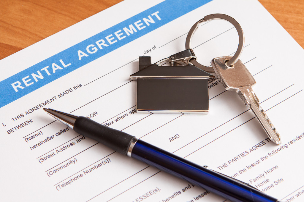 A rental agreement document, a pen, and a key