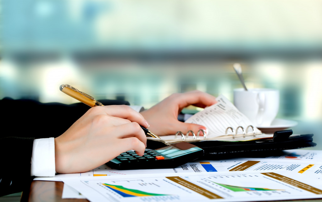 An accountant using a calculator to manage financials