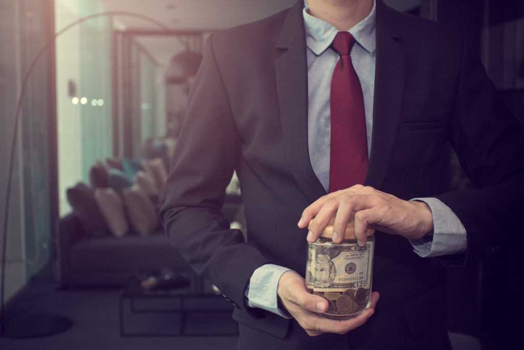 business man holding a jar of money