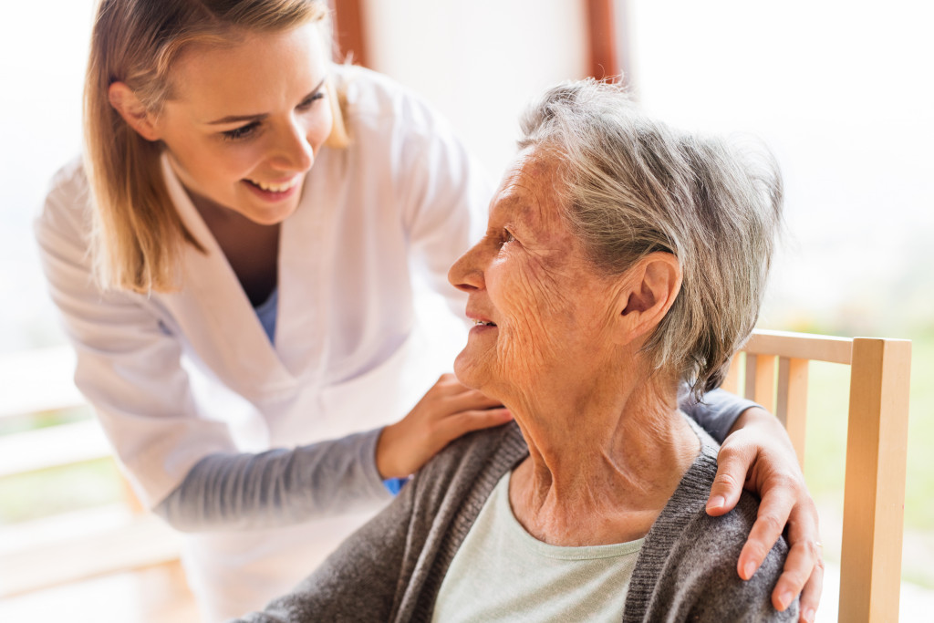a female care provider holding a senior woman