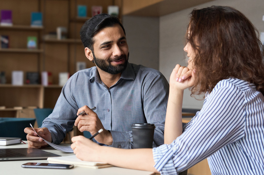 Two remote workers discussing ideas at a conference table in a co-working area