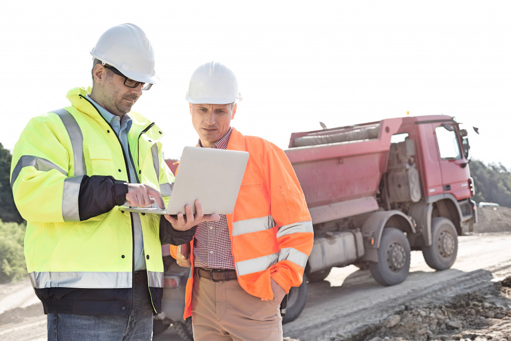 two construction workers discussing the plan in a laptop on the site