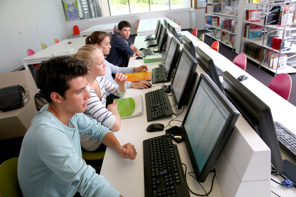 teens on a library using a computer