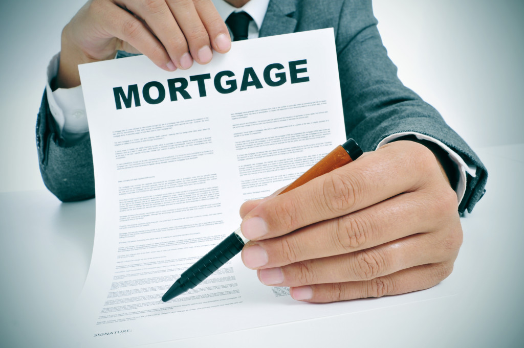 A man handing over a pen and a mortgage document