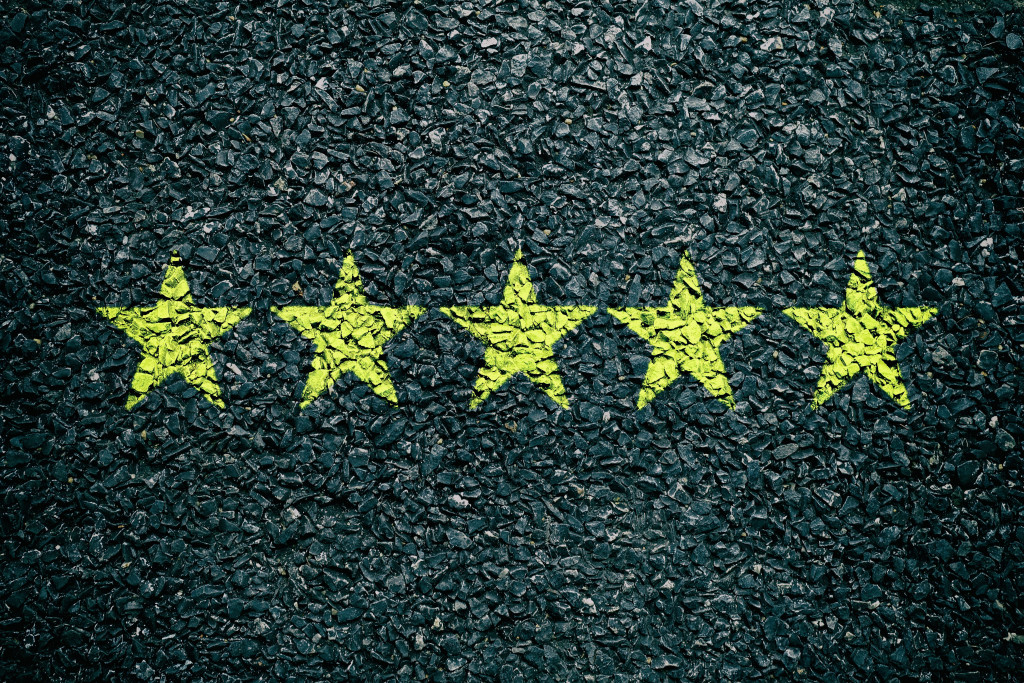 five stars on asphalt background concept of customer reviews