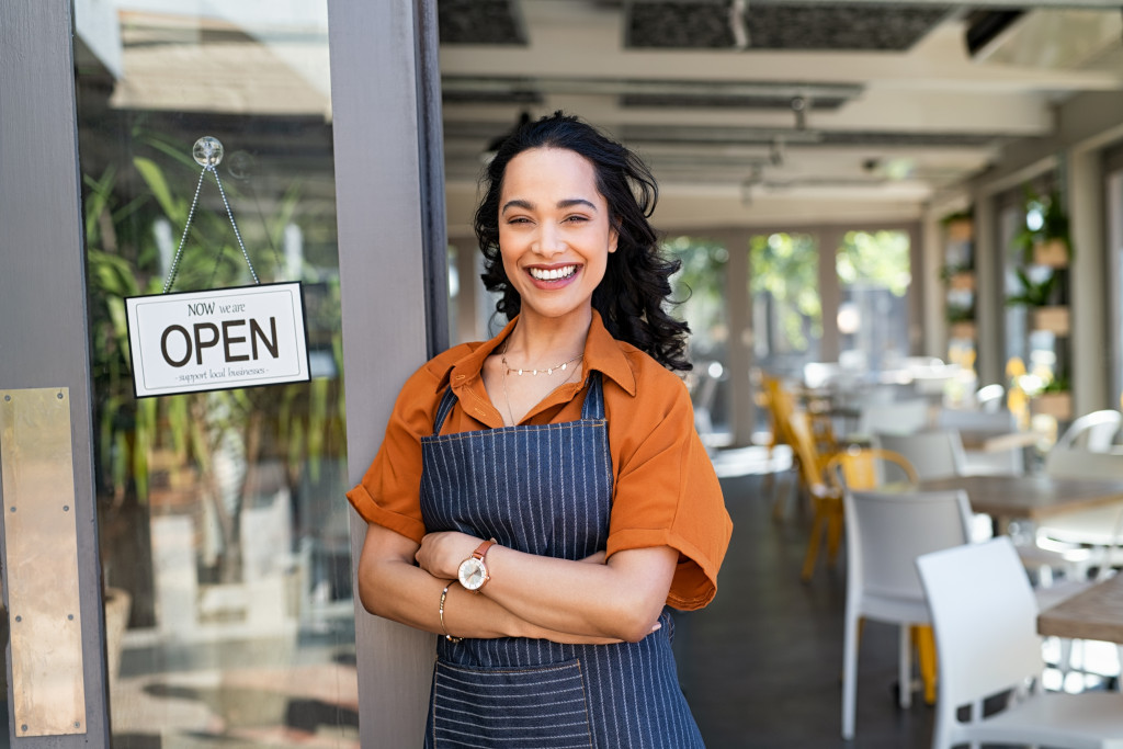 A businesswoman standing in front of her restaurant