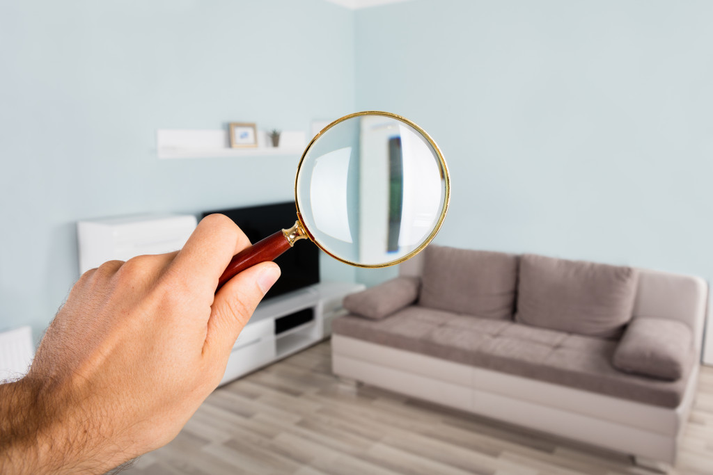 A property being inspected for damage using a magnifying glass