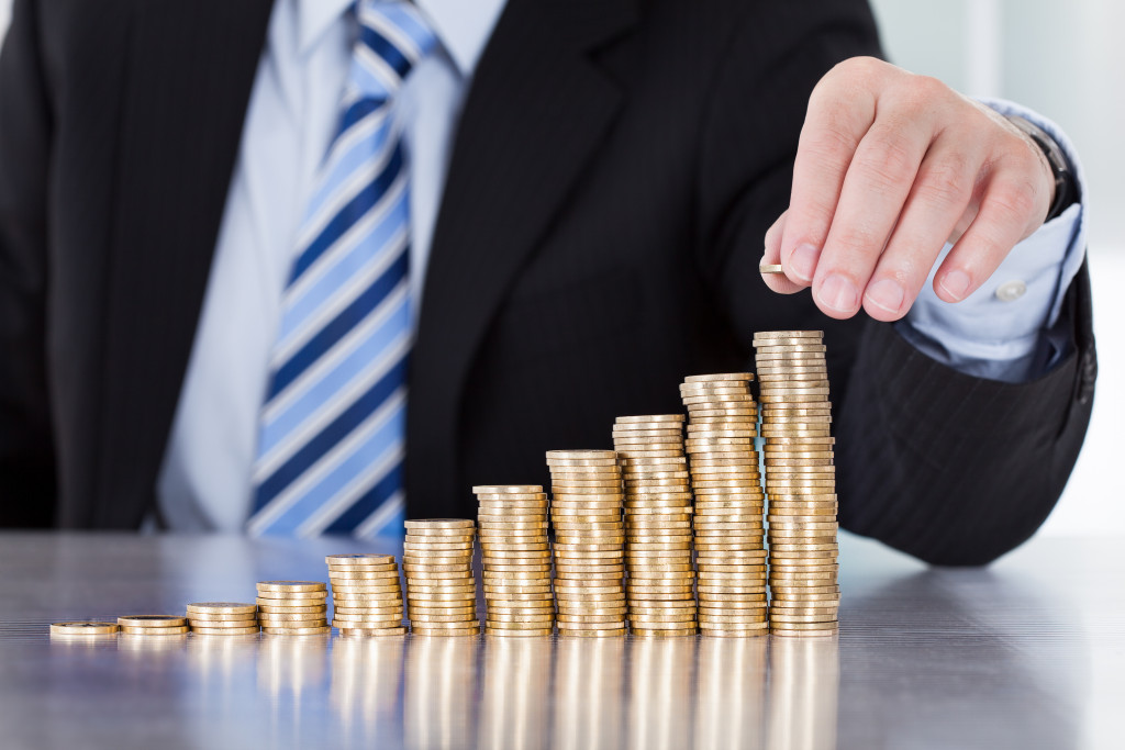 A businessman stacking coins in a rising order