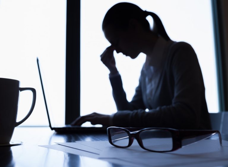 A worried businesswoman looking at her laptop