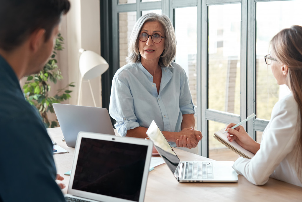 A mature businesswoman mentoring younger professionals in an office