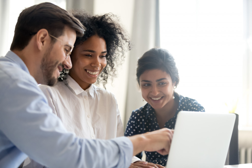 A businessman teaching interns on a computer