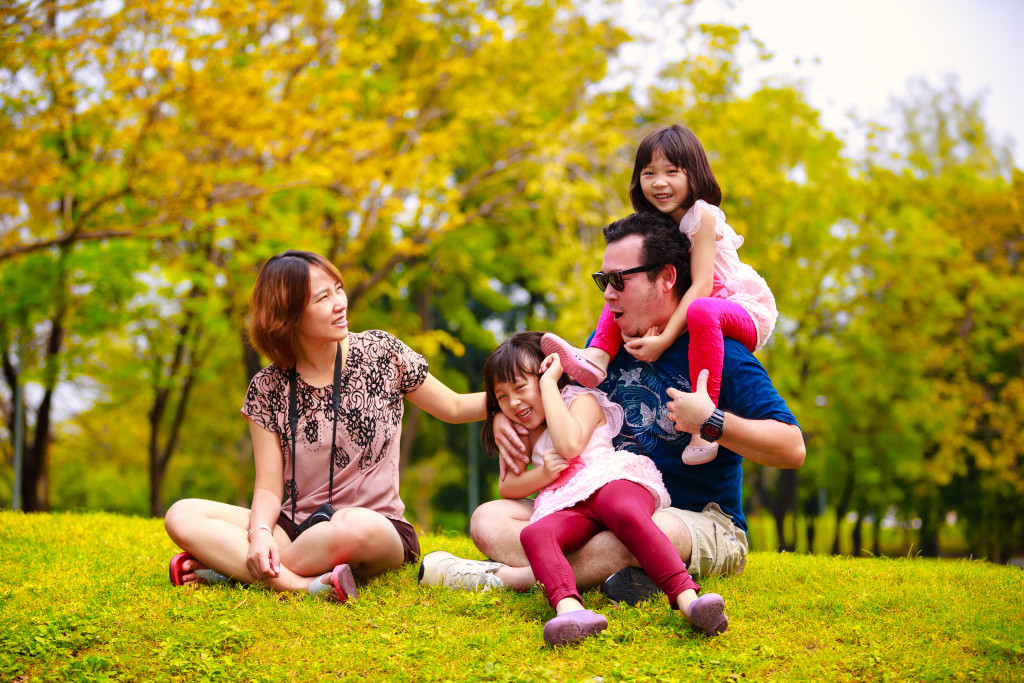 Small family sitting outdoors while having fun.