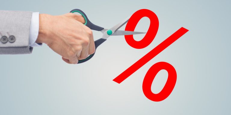 A businessman using scissors to cut a red percentage sign
